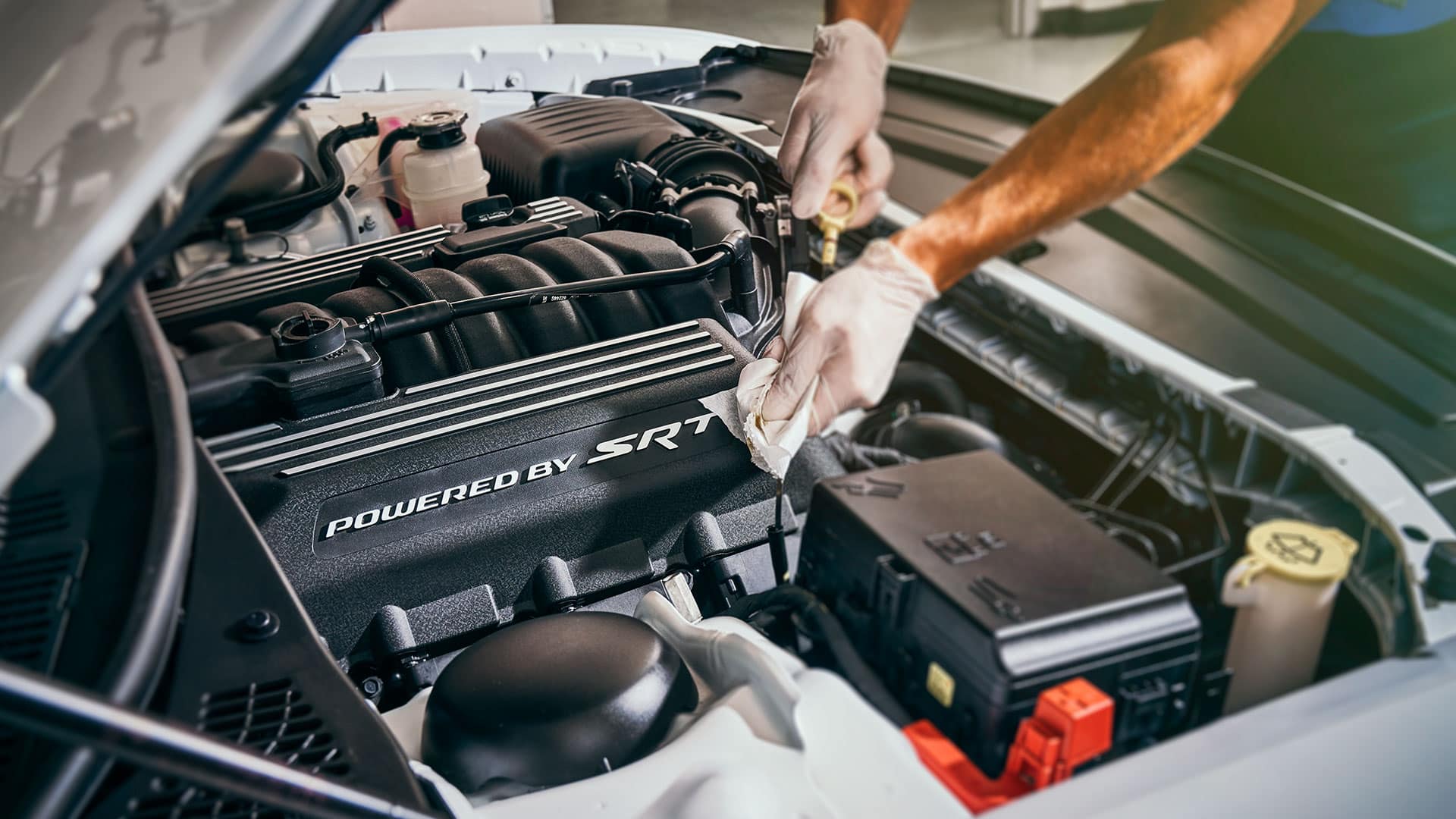 Mechanic performing oil change on Jeep, Dodge, or Ram vehicle